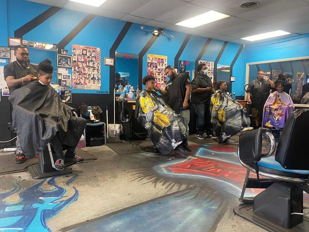 Inside King's Cutz with barbers at work in the blue shop